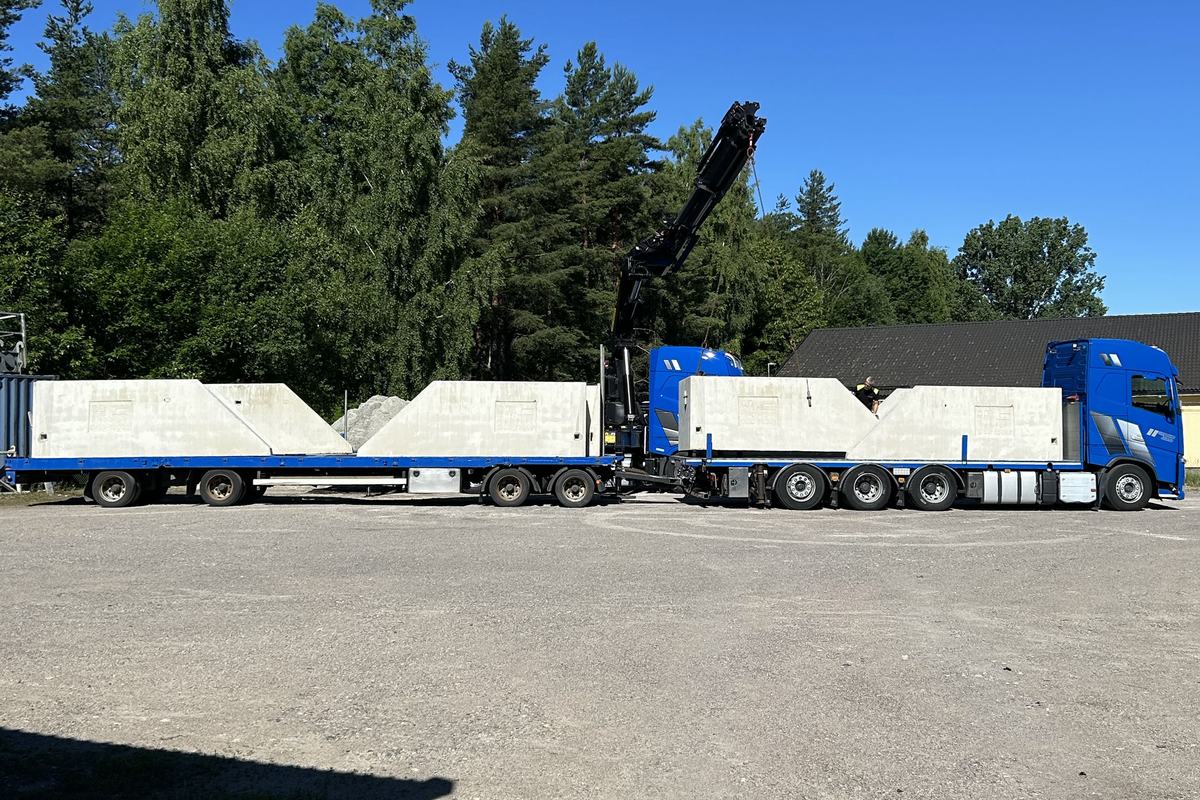 Fullastat ekipage med sidoväggar i betong på flak och släp.