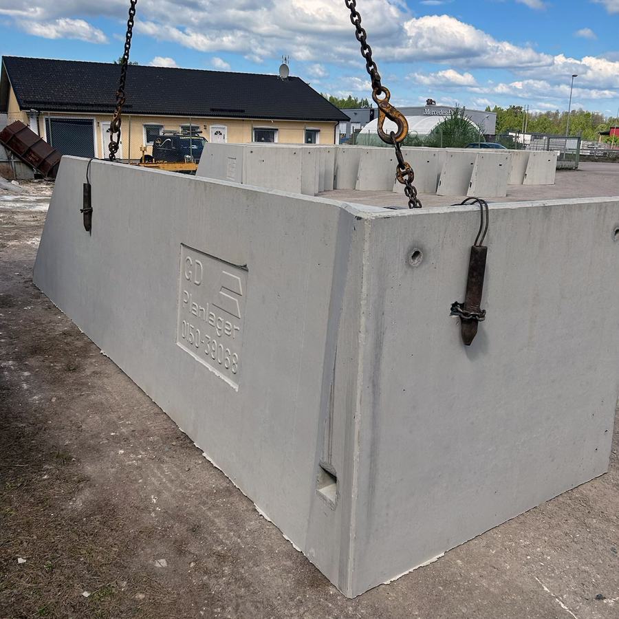 Sidovägg lyft i kättingar med den ingjutna GD Planlager-stämpeln synlig.