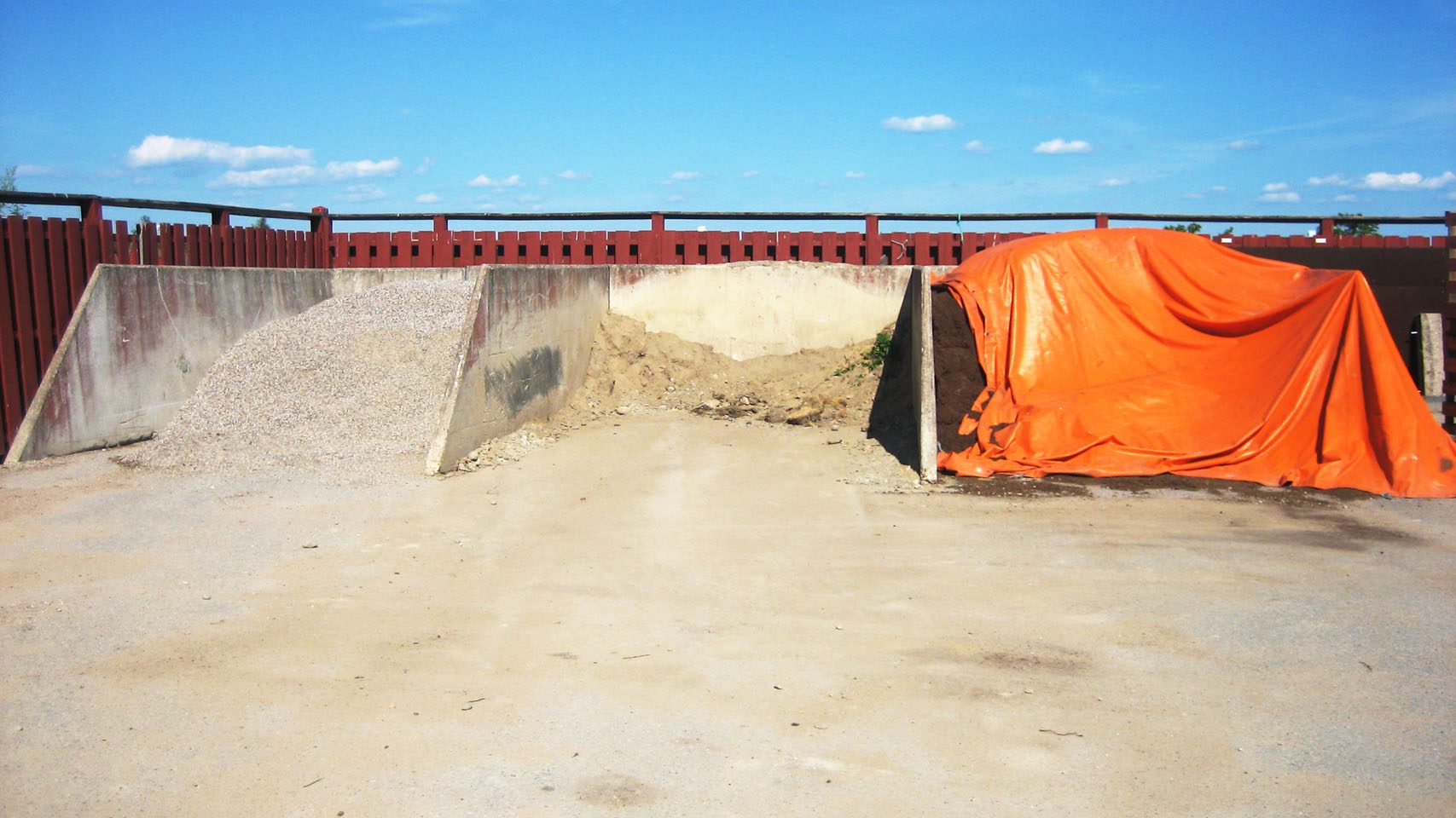 Tre fack i GD Planlager fyllda med makadam, sand och täckt jord, avdelade av L-formade betongelement.